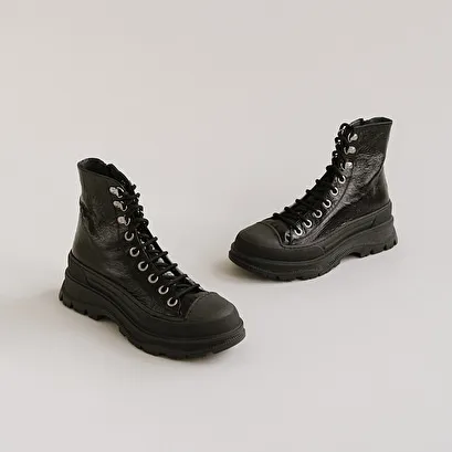 Boots with laces and notched soles in black aged leather